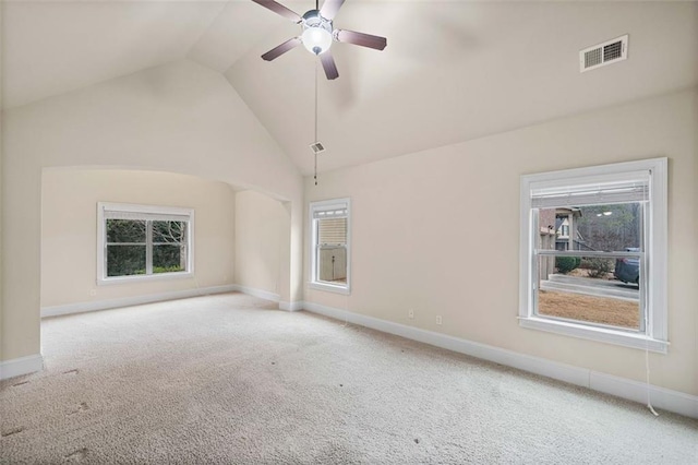 carpeted spare room featuring vaulted ceiling and ceiling fan