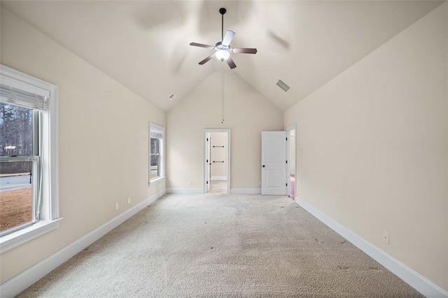 carpeted spare room featuring ceiling fan and high vaulted ceiling