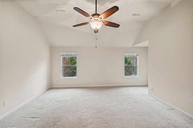 empty room with ceiling fan, vaulted ceiling, and light carpet