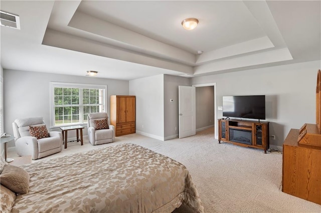 carpeted bedroom with a tray ceiling