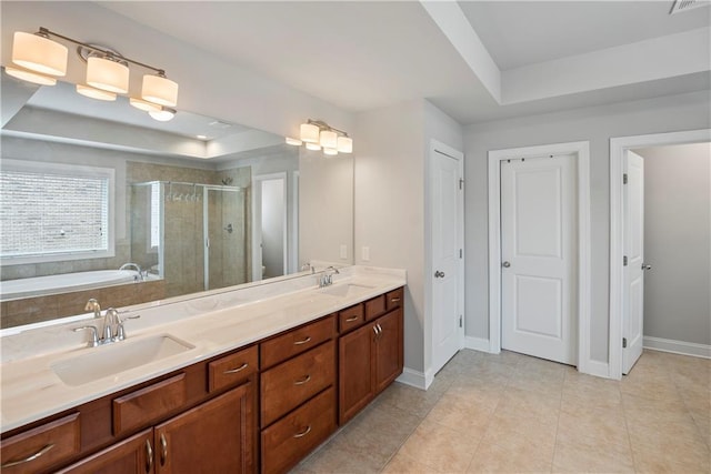 bathroom with vanity, a tray ceiling, tile patterned floors, and plus walk in shower