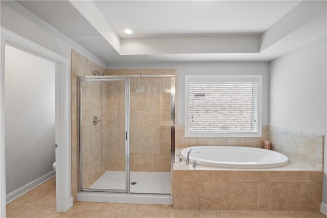 bathroom featuring tile patterned flooring, a raised ceiling, toilet, and separate shower and tub