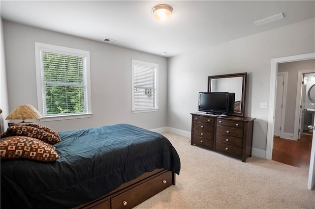 carpeted bedroom with stacked washer and dryer