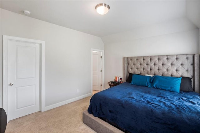 bedroom featuring light colored carpet and vaulted ceiling