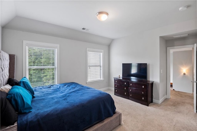 bedroom with light colored carpet and vaulted ceiling