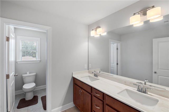 bathroom with tile patterned flooring, vanity, and toilet