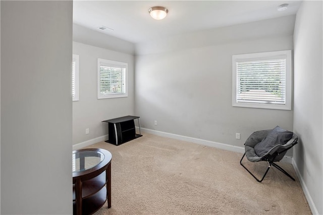 living area featuring light carpet