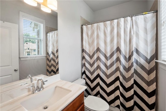 bathroom featuring vanity, toilet, and walk in shower