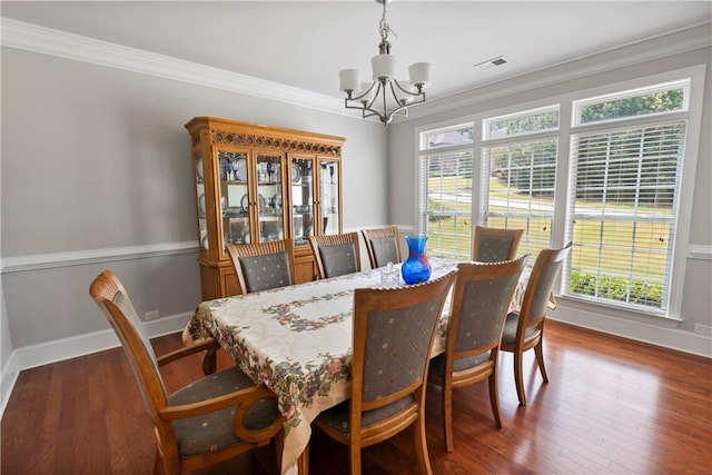 dining space with ornamental molding, dark hardwood / wood-style flooring, and a chandelier