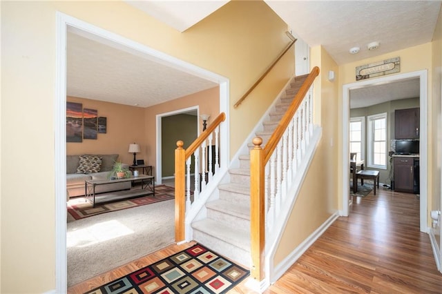 3090 Perch Ln SW, Marietta, GA 30008 - stairs featuring wood finished floors, a textured ceiling, and baseboards