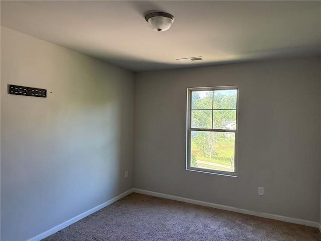 carpeted spare room featuring baseboards