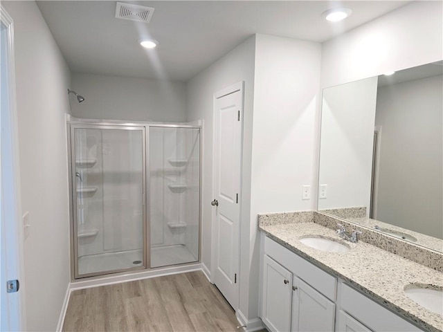 bathroom featuring walk in shower, wood-type flooring, and vanity