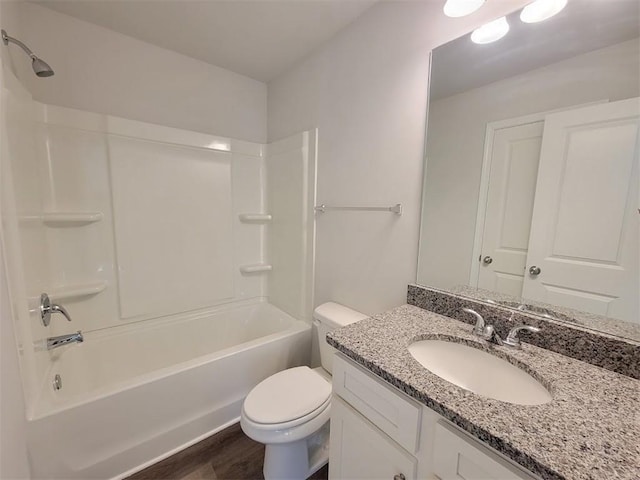 full bathroom with washtub / shower combination, vanity, toilet, and hardwood / wood-style floors