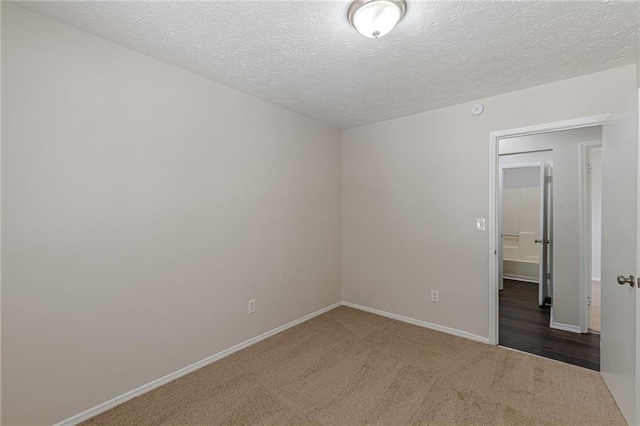 carpeted spare room featuring a textured ceiling