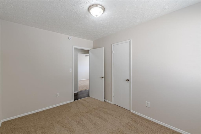 unfurnished bedroom with a closet, carpet floors, and a textured ceiling