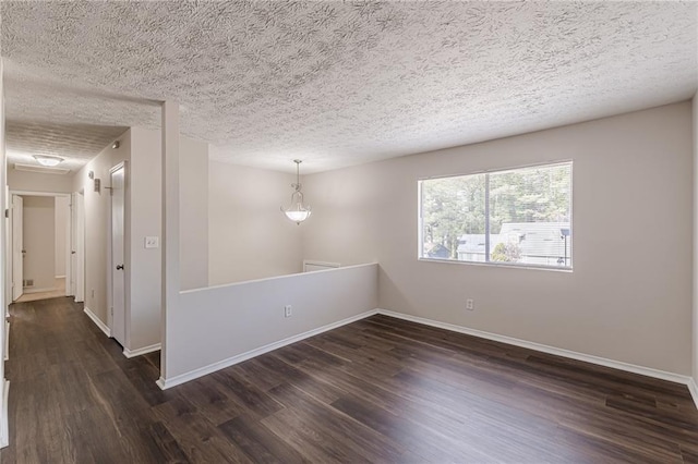 empty room featuring dark hardwood / wood-style floors and a textured ceiling