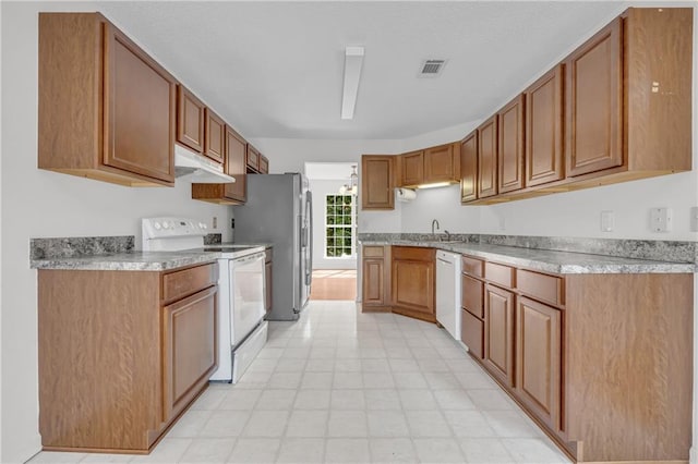 6440 Narramore Way, Lula, GA 30554 - kitchen featuring white appliances, under cabinet range hood, brown cabinets, and a sink