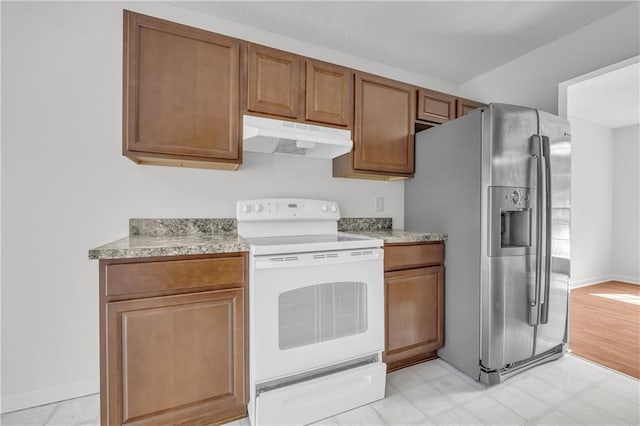 6440 Narramore Way, Lula, GA 30554 - kitchen with white range with electric cooktop, under cabinet range hood, stainless steel fridge, and brown cabinetry