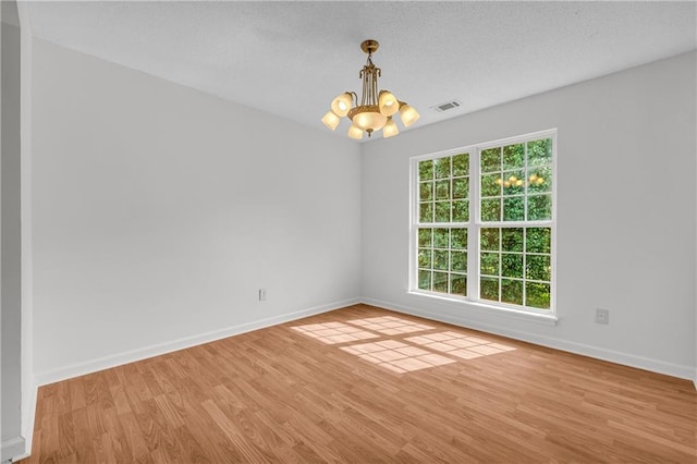 6440 Narramore Way, Lula, GA 30554 - spare room with a chandelier, light wood finished floors, baseboards, and a textured ceiling