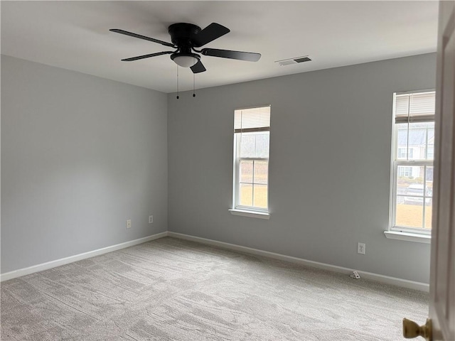 unfurnished room with a ceiling fan, baseboards, visible vents, and carpet flooring