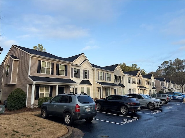 view of property with uncovered parking and a residential view