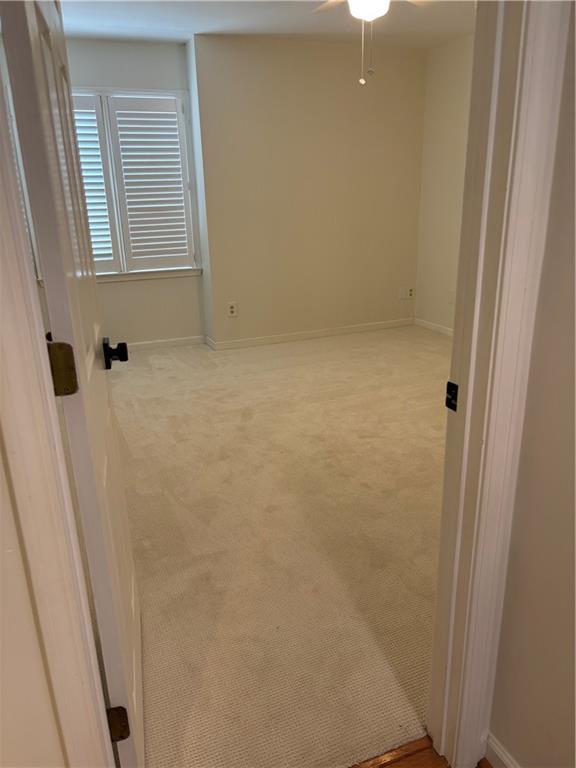 spare room with baseboards, ceiling fan, and carpet flooring