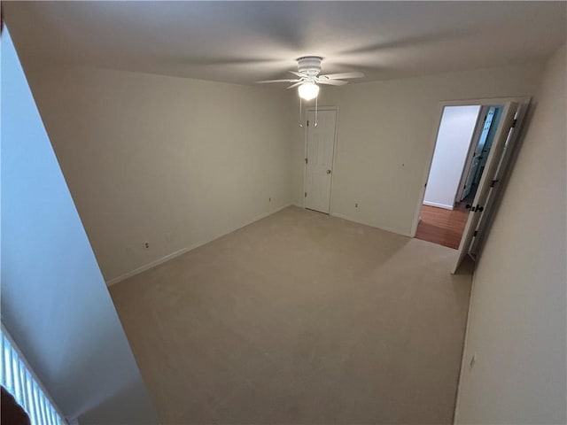 unfurnished room featuring baseboards, ceiling fan, and light carpet