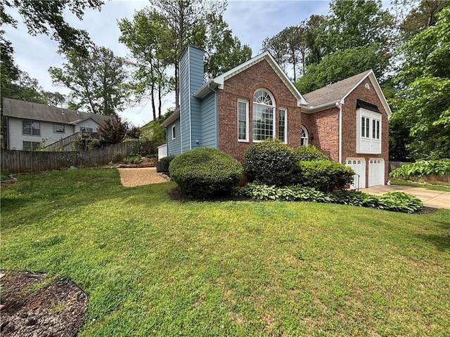 exterior space featuring a garage, fence, a chimney, brick siding, and driveway