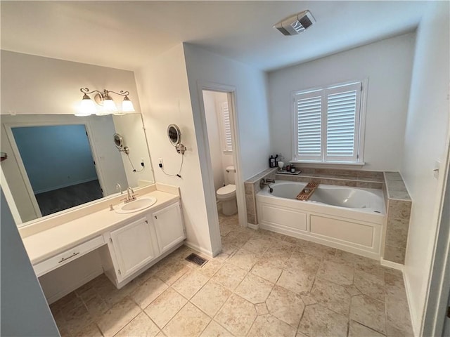 bathroom featuring toilet, visible vents, a garden tub, and vanity