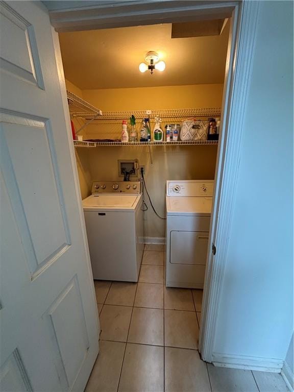 washroom with separate washer and dryer, baseboards, laundry area, and light tile patterned flooring