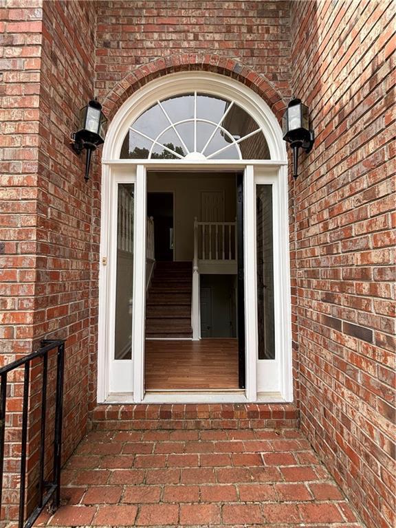doorway to property with brick siding