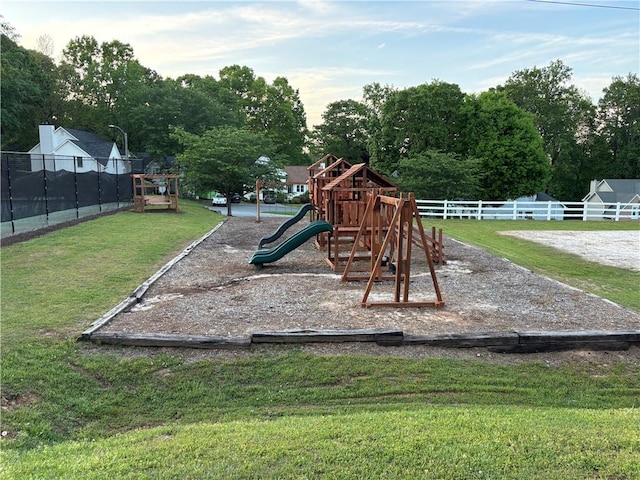 community play area with a lawn and fence