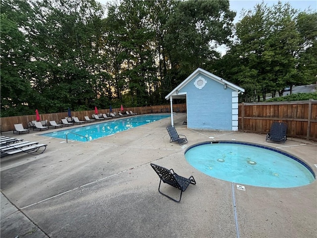 community pool featuring fence and a patio area