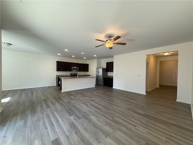 unfurnished living room with dark wood-type flooring, baseboards, and a ceiling fan