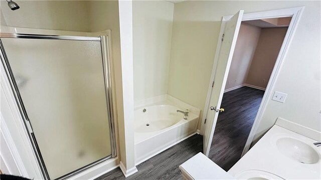 bathroom featuring hardwood / wood-style flooring, vanity, and separate shower and tub