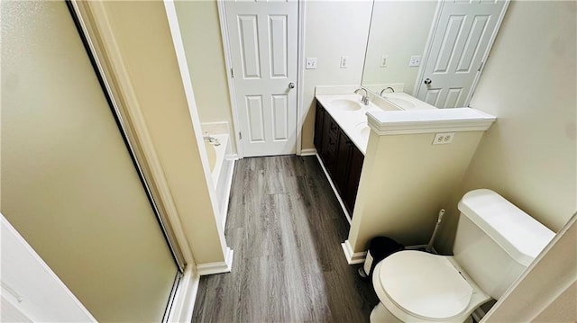 full bathroom with hardwood / wood-style floors, vanity, separate shower and tub, and toilet