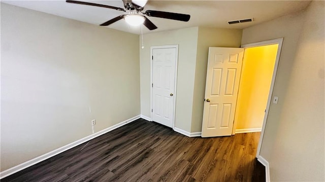 unfurnished bedroom with ceiling fan and dark wood-type flooring