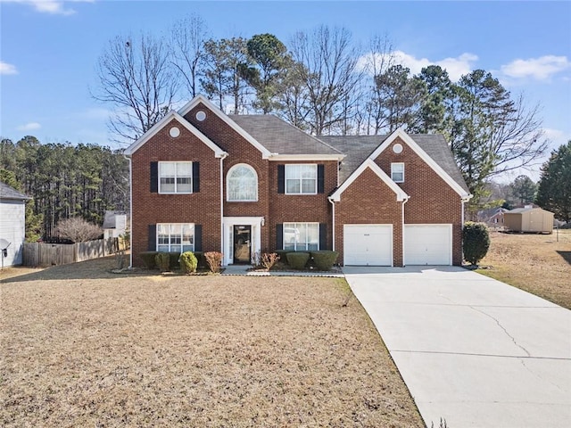 colonial home with brick siding, fence, driveway, and an attached garage