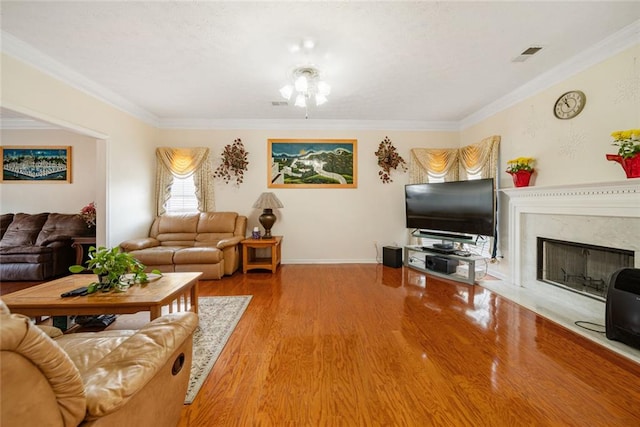 living room featuring ornamental molding, visible vents, and wood finished floors