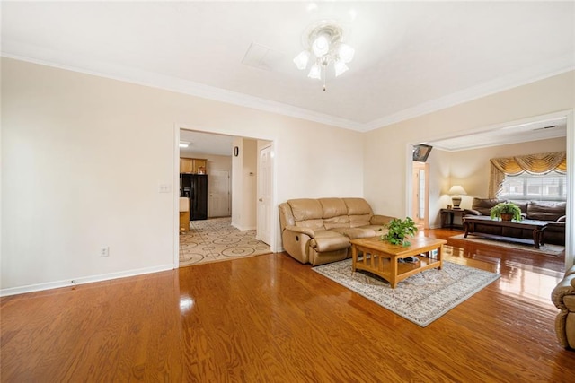 living room featuring light wood-style floors, baseboards, and ornamental molding