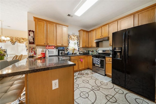 kitchen with under cabinet range hood, a peninsula, visible vents, a kitchen breakfast bar, and appliances with stainless steel finishes