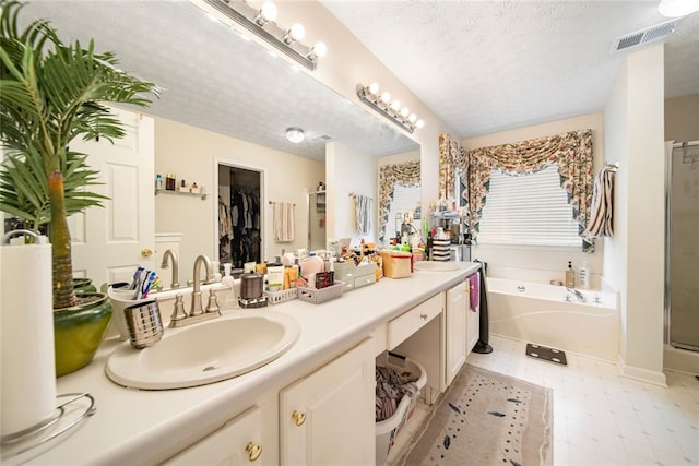 full bath featuring visible vents, a garden tub, a textured ceiling, vanity, and a shower stall