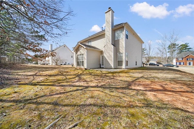 rear view of house featuring a chimney and a patio