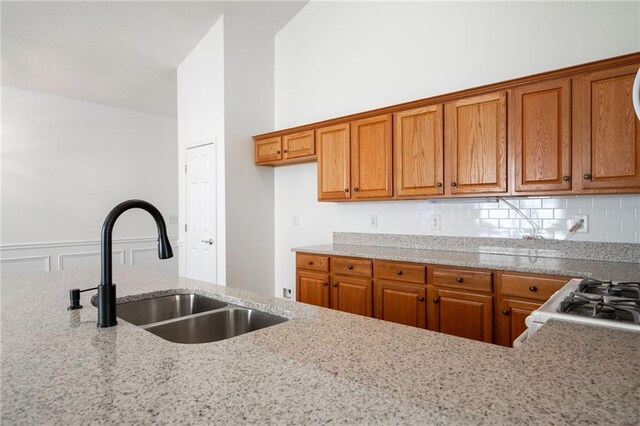 kitchen with kitchen peninsula, sink, white appliances, and hardwood / wood-style flooring