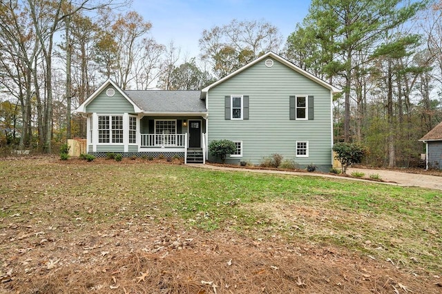 tri-level home with covered porch and a front lawn