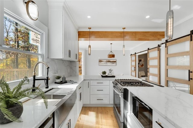 270 Boulder Dr, Roswell, GA 30075 - kitchen featuring a barn door, light stone countertops, stainless steel gas stove, backsplash, and light wood-type flooring