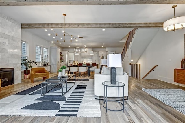 living room featuring a fireplace, an inviting chandelier, and light wood-type flooring