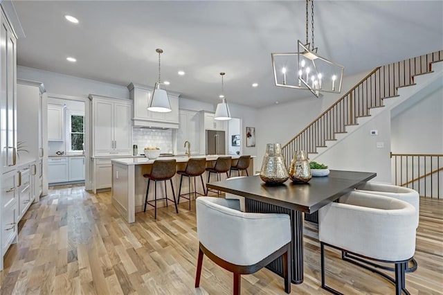 dining area with light wood-type flooring and a chandelier