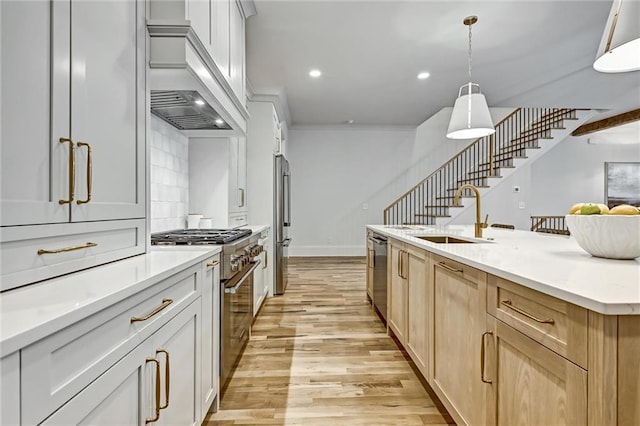 kitchen with sink, backsplash, pendant lighting, light brown cabinetry, and appliances with stainless steel finishes