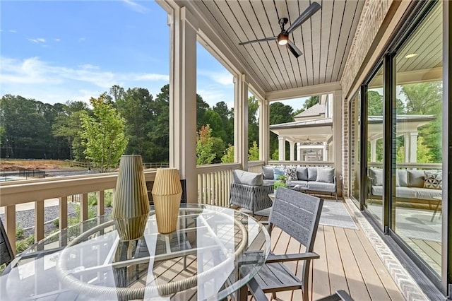 sunroom featuring ceiling fan and wooden ceiling